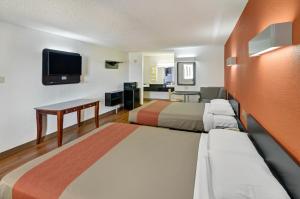 a hotel room with two beds and a flat screen tv at Motel 6-Lindale, TX in Lindale