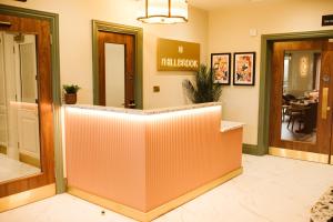 a lobby with a reception counter and a dining room at The Hillbrook Hotel & Spa - Sherborne in Sherborne