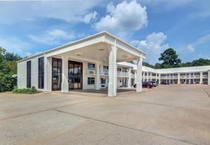 a large white building with a parking lot at Motel 6-Lindale, TX in Lindale