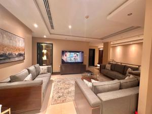 a living room with couches and a flat screen tv at Luxury apartments Alkhobar in Al Khobar