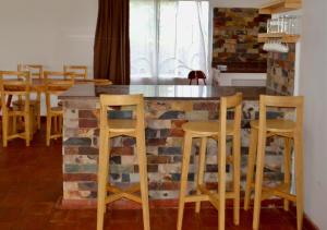 a kitchen with a brick counter with stools around it at Kalunga Holiday Home in Banda