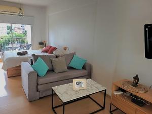 sala de estar con sofá y cama en Luminoso y cómodo departamento con balcón en Buenos Aires