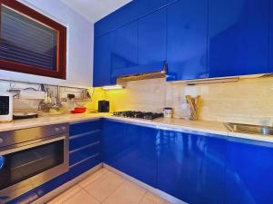 a kitchen with blue cabinets and a sink at Casa Le Focette by Nicola Real Estate in Marina di Pietrasanta