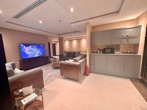 a kitchen and a living room with a tv and a couch at Luxury apartments Alkhobar in Al Khobar