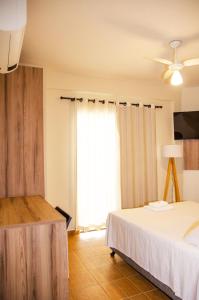 a bedroom with a bed and a large window at Hotel Zé Maria in Pouso Alegre