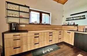 a large kitchen with wooden cabinets and a sink at Chata u Hrušků 100m od sjezdovky in Oravská Lesná