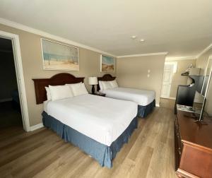 a hotel room with two beds and a desk at Cape Cod Family Resort and Parks in West Yarmouth