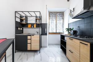 ローマにあるGianicolense Apartmentのキッチン(黒と木のキャビネット付)、窓