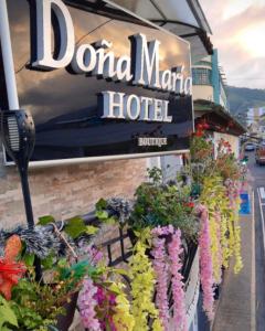 un letrero para un hotel en el puerto deportivo con flores en Hotel Boutique Doña Maria, en Ocaña