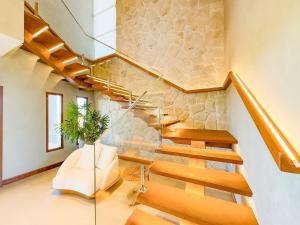 a glass staircase in a home with a stone wall at Maruwá - Villa Deluxe 30 in Mata de Sao Joao