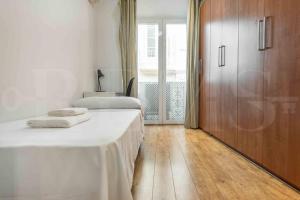 een slaapkamer met 2 bedden en een houten vloer bij Charming apartment with private patio by REMS in Málaga