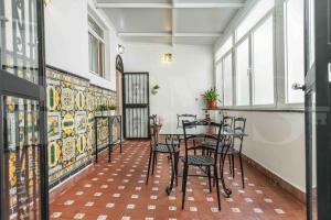 een kamer met een tafel, stoelen en ramen bij Charming apartment with private patio by REMS in Málaga