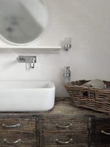 ein Bad mit einem Waschbecken und einem Korb auf der Theke in der Unterkunft Haus am Deich 47 stilvolles Landhaus an der Elbe in Stadtnähe in Hamburg