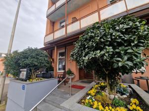 um edifício com duas árvores e flores em frente em Plaza em Kreuzlingen