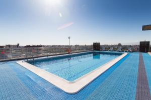 a swimming pool with a swimming pool in the middle of it at Expo Hotel Valencia in Valencia