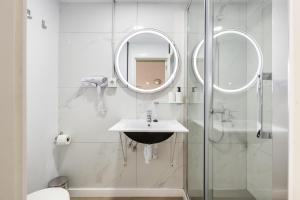 a bathroom with a sink and a shower with a mirror at Regina Selfcheck-in Smart Rooms in Palma de Mallorca