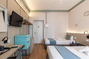 パルマ・デ・マヨルカにあるRegina Selfcheck-in Smart Roomsのベッド2台、薄型テレビが備わるホテルルームです。
