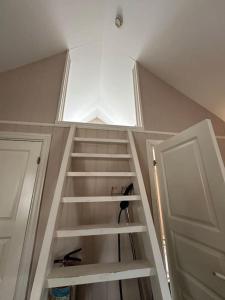 een trap in een kamer met een raam en een deur bij Lite hus til leie sommeren 2024 in Arendal