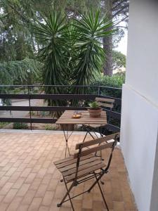 a wooden table and a chair on a patio at Tenuta SGB - Il profumo del vino Etna Nicolosi in Nicolosi