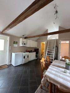 een keuken met een tafel en een witte koelkast bij Lite hus til leie sommeren 2024 in Arendal