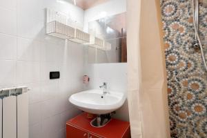 y baño blanco con lavabo y ducha. en Casa Vacanze Il Torchio Due, en Pegui