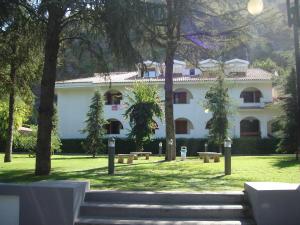 duży biały budynek z drzewami przed nim w obiekcie Villaggio Turistico La Mantinera - Hotel w mieście Praia a Mare