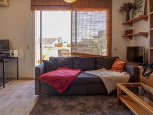 - un salon avec un canapé et une grande fenêtre dans l'établissement Castell Apartment by Hello Homes Sitges, à Sitges
