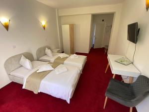 um quarto de hotel com duas camas e uma mesa em Chalet Wiese em Poiana Brasov