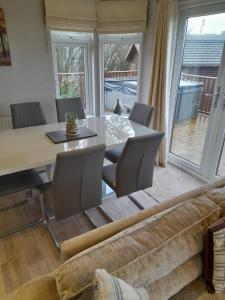 a living room with a couch and a table at Devon Hills Holiday Park luxury timber lodge pet friendly with hot tub 2 to 6 guests in Paignton