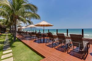a wooden deck with chairs and umbrellas on the beach at Flat Pietra in Florianópolis