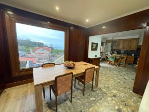 una sala da pranzo con tavolo e una grande finestra di Casa de vacaciones a Baiona