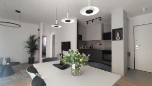 a kitchen and dining room with a white table and chairs at Apartman Spalatum in Split