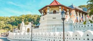 a white fence in front of a building at Sobasee Deluxe Bungalow in Kandy