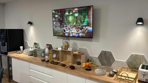 a television hanging on a wall above a counter at HOTEL SON VILAR in Es Castell