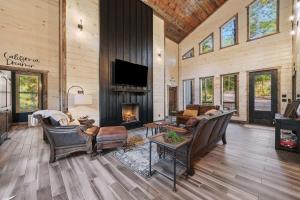 Una sala de estar con sofás y chimenea. en New Cabin w Hot Tub + Views Sleeps 12, en Broken Bow