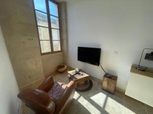 a living room with a leather chair and a television at T1 Bis Centre Historique Auch in Auch