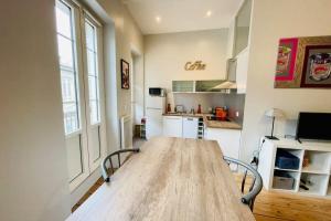 eine Küche mit einem großen Holztisch in einem Zimmer in der Unterkunft Lafite furnished flat in Bordeaux