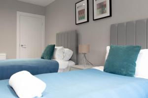 格拉斯哥的住宿－Castlemilk House，一间卧室配有两张蓝色和白色的床