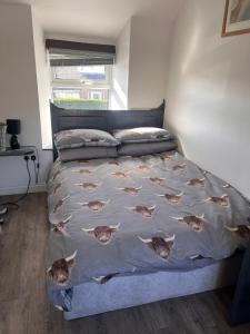 a bedroom with a bed with a blanket with fish on it at RB Contractor Stays - Ty Capel in Pwllheli