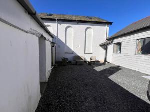a courtyard of a white building next to a building at RB Contractor Stays - Ty Capel in Pwllheli