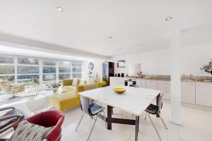 een keuken en een woonkamer met een tafel en stoelen bij 1 Bed Maisonette with Garden - 1 min to station Share Save in Londen