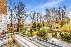 a view from the balcony of a house with trees at 1 Bed Maisonette with Garden - 1 min to station Share Save in London