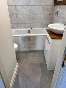 a bathroom with a sink and a tub and a toilet at RB Contractor Stays - Ty Capel in Pwllheli