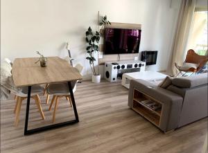 uma sala de estar com uma mesa e um sofá em Cosy Flat Cannes em Le Cannet