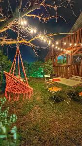 patio ze stołem, krzesłami i światłami w obiekcie Ciriga Sicily Glamping Resort w mieście Santa Maria del Focallo