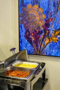 a buffet with a painting on the wall and food at Flat Pietra in Florianópolis