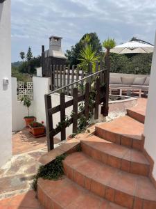 a set of stairs with a fence and an umbrella at Casas Asomada in Tanque