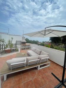 eine Terrasse mit zwei weißen Sofas und einem Sonnenschirm in der Unterkunft Casas Asomada in Tanque