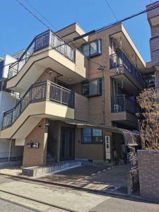 名古屋市にあるPeace & Harmonyのバルコニーと階段が備わるアパートメントビルディング