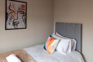 um quarto com uma cama com uma almofada colorida em Linwood House em Paisley